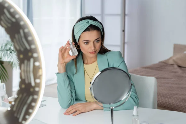 Stylish Woman Proposing Face Serum Ring Lamp Mirror — Stock Photo, Image