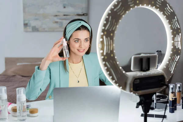 Elegante Donna Che Mostra Bottiglia Spray Acqua Micellare Vicino Computer — Foto Stock