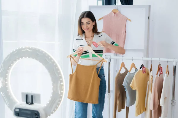 Χαρούμενη Blogger Μόδας Κρατώντας Ετικέτα Την Πώληση Επιστολόχαρτα Κοντά Ρούχα — Φωτογραφία Αρχείου