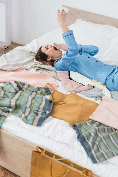 Tired Woman Yawning Video Call Plenty Clothes Bed — Stock Photo, Image
