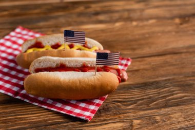 Tahta yüzeyinde küçük Amerikan bayrakları olan lezzetli sosisliler.