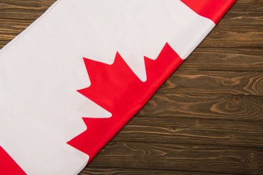 Ahşap yüzey üzerinde akçaağaç yaprağı olan Kanada bayrağının üst görüntüsü 