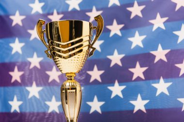 golden cup with stars of american flag on blurred background clipart