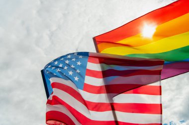 Düşük açılı Amerikan ve renkli lgbt bayrakları gökyüzüne karşı 