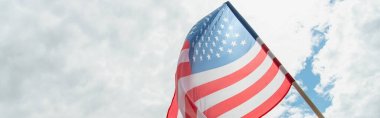 Bulutlu gökyüzüne karşı Amerikan bayrağının alçak açılı görüntüsü, afiş