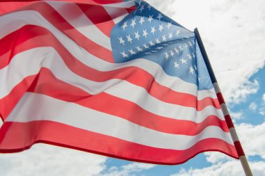 Düşük açılı Amerikan bayrağı bulutlu gökyüzüne karşı yıldızlar ve çizgiler 