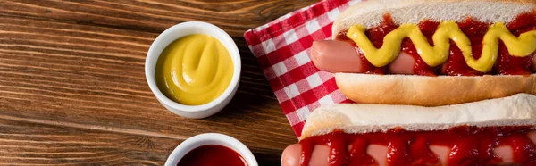 Bovenaanzicht Van Saus Kommen Buurt Van Hotdogs Geruite Servet Houten — Stockfoto