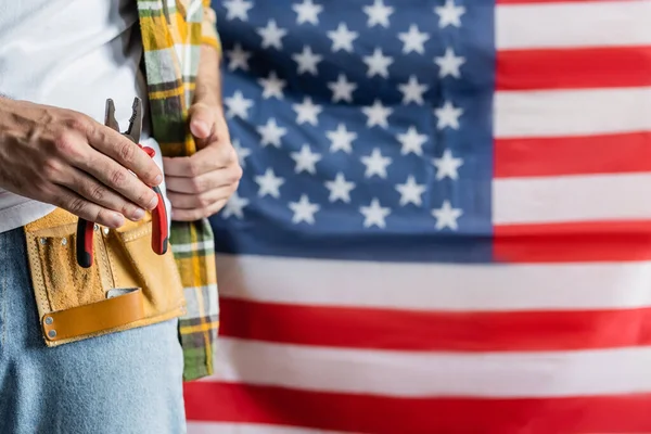 Partiell Bild Arbetare Verktygsbälte Hålla Tång Nära Suddig Usa Flagga — Stockfoto