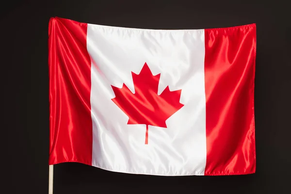 Canadian flag with red maple leaf isolated on black