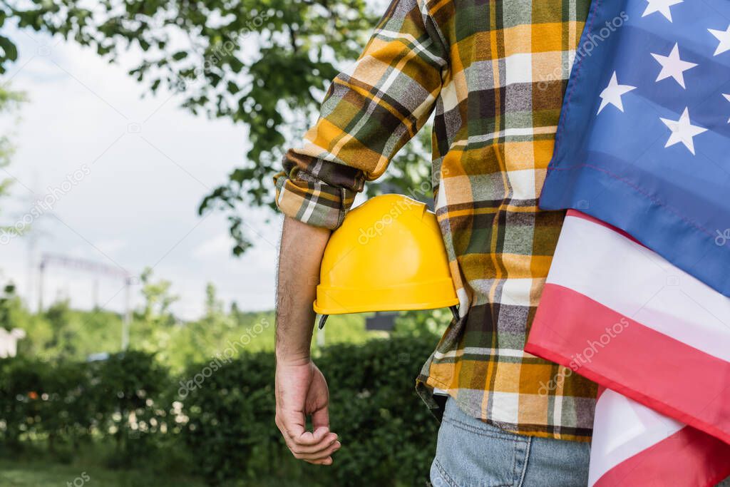 back view of cropped foreman with usa flag and hardhat outdoors, labor day concept