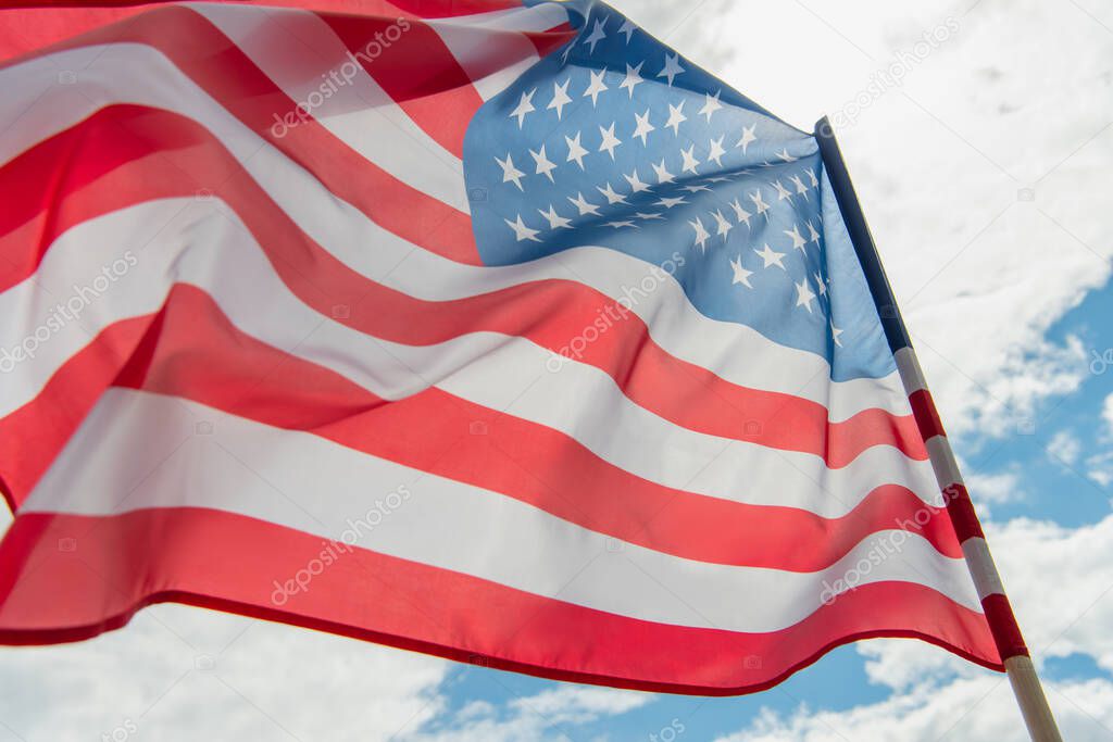 low angle view of american flag with stars and stripes against cloudy sky 