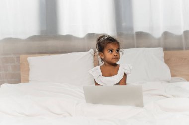 toddler african american kid using laptop in bedroom clipart