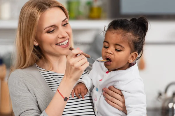 Alegre Madre Celebración Cuchara Alimentación Adoptado Africano Americano Hija —  Fotos de Stock