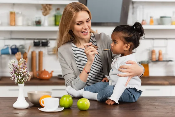 Alegre Mujer Celebración Cuchara Alimentación Adoptado Africano Americano Niño — Foto de Stock