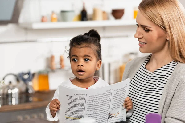 Feliz Madre Mirando Adoptado Africano Americano Niño Con Periódico — Foto de Stock