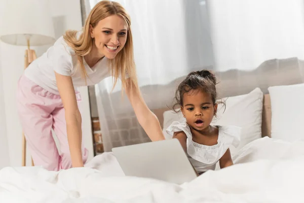 Happy Mother Adopted African American Girl Watching Movie Laptop Bedroom — Stock Photo, Image