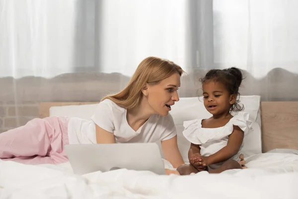 Surprised Mother Adopted African American Girl Watching Movie Laptop Bedroom — Stock Photo, Image