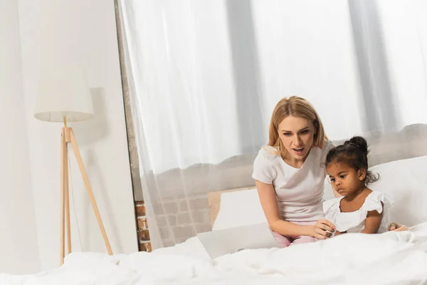 Amazed Mother Adopted African American Kid Watching Movie Laptop Bedroom — Stock Photo, Image