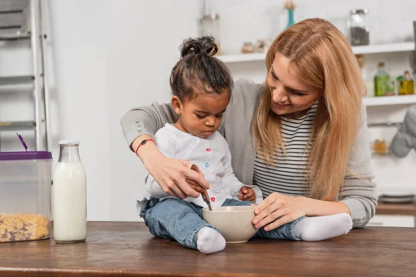 Adoptált Afro Amerikai Gyerek Gazdaság Kanál Közelében Tál Miközben Konyhaasztalon — Stock Fotó