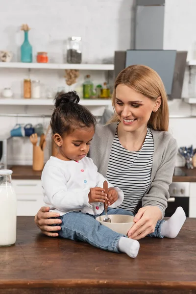 Happy Mother Looking Adopted African American Kid Spoon Sitting Kitchen — Stock Photo, Image