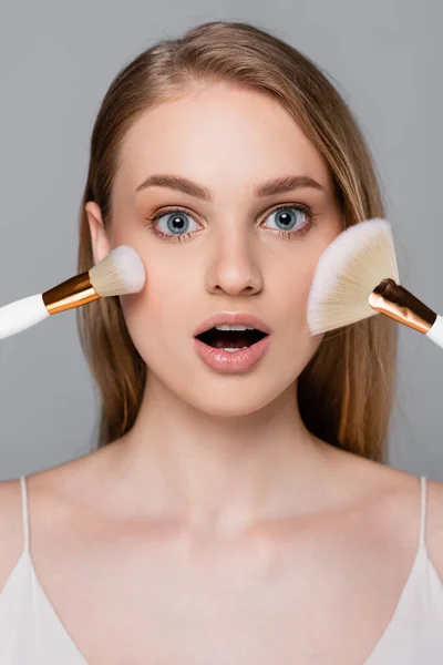 Amazed Young Woman Holding Cosmetic Brushes Face Isolated Grey — Stock Photo, Image
