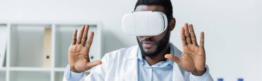 Afrikalı Amerikalı doktor klinikte vr kulaklık kullanıyor. 