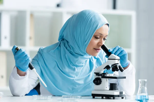 Arabian Scientist Hijab Looking Microscope Holding Electronic Pipette —  Fotos de Stock