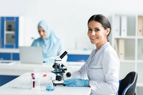 Smiling Scientist Latex Gloves Looking Camera Microscope Equipment — Stock fotografie