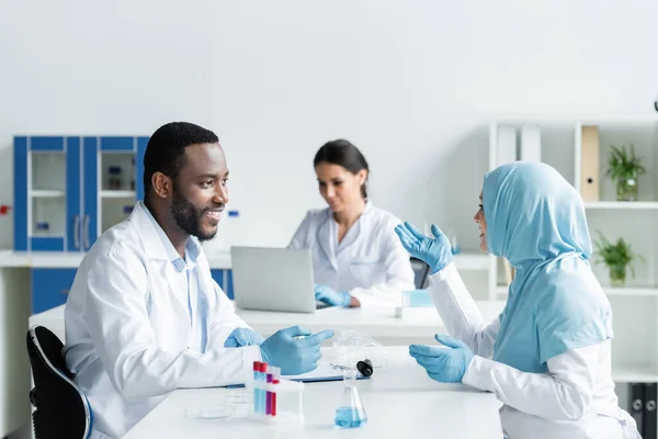 Усміхнені Багатоетнічні Вчені Розмовляють Біля Медичного Обладнання Лабораторії — стокове фото