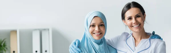 Interracial Doctors Smiling Camera While Embracing Banner — Stock Fotó