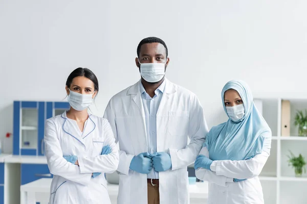 Πολυεθνικοί Γιατροί Ιατρικές Μάσκες Που Στέκονται Στο Νοσοκομείο — Φωτογραφία Αρχείου