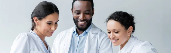 Smiling Interracial Doctors Looking Clinic Banner — Stock Photo, Image