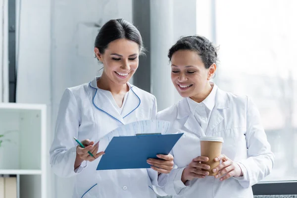 Médicos Multiétnicos Com Café Prancheta Sorrindo Hospital — Fotografia de Stock