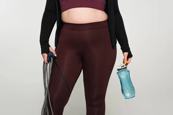 スポーツボトルを保持し グレーに隔離されたジャンプローププラスサイズのスポーツ女性の作物ビュー — ストック写真