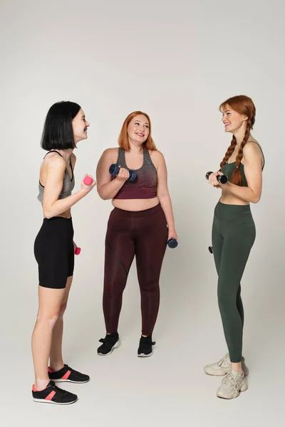 Body Positive Women Smiling While Exercising Dumbbells Grey Background — Stock Photo, Image