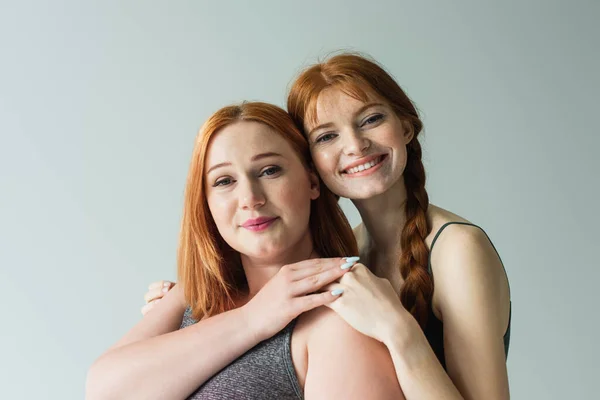 Freckled Sportswoman Hugging Size Friend Isolated Grey — Stock Photo, Image