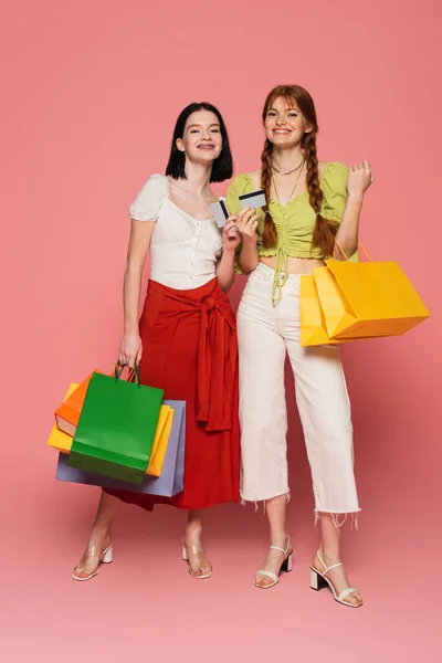 분홍색 배경에 카드와 쇼핑백을 백반증 주근깨를 여성을 유혹하는 — 스톡 사진