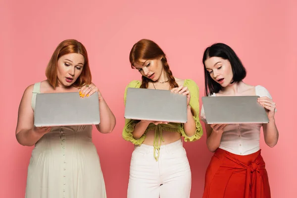 Donne Stupite Che Tengono Computer Portatili Isolati Rosa — Foto Stock