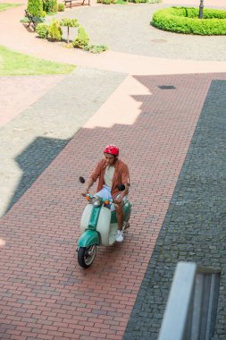 Kare üzerinde scooter süren Afro-Amerikan bir adamın yüksek açılı görüntüsü