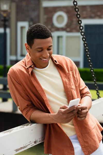 Χαρούμενος Αφροαμερικάνος Που Χρησιμοποιεί Κινητό Τηλέφωνο Στην Αστική Γέφυρα — Φωτογραφία Αρχείου
