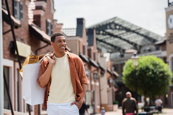 Sorrindo Afro Americano Homem Segurando Shoppings Sacos Enquanto Com Mão — Fotografia de Stock