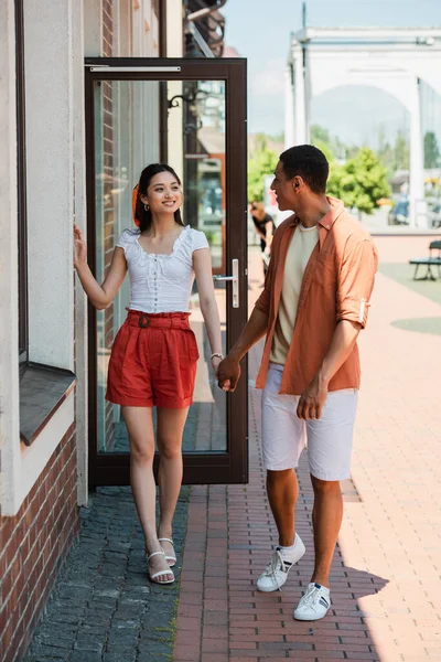 Stylish Multiethnic Couple Looking Each Other Holding Hands Building Street — Stock Photo, Image