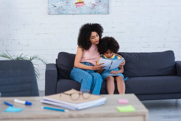 Mère Afro Américaine Tenant Cahier Près Fille Sur Canapé — Photo