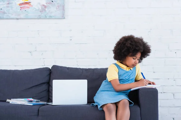 African American Kid Writing Notebook Laptop Couch — Stock Photo, Image