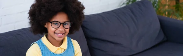 Criança Afro Americana Óculos Olhando Para Câmera Sofá Banner — Fotografia de Stock