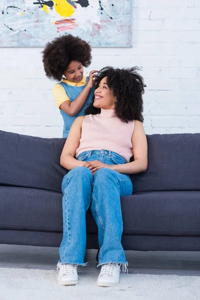 African American Girl Touching Hair Mother Couch Living Room — Stock Photo, Image