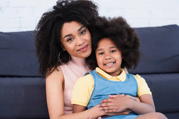 Mujer Afroamericana Abrazando Hija Sonriente Casa — Foto de Stock