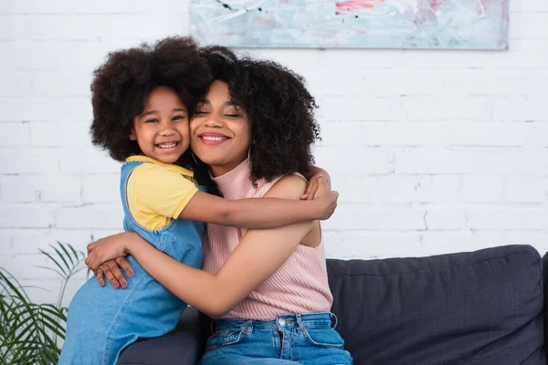 Mor Med Slutna Ögon Omfamnar Positiv Afrikansk Amerikansk Unge Vardagsrummet — Stockfoto