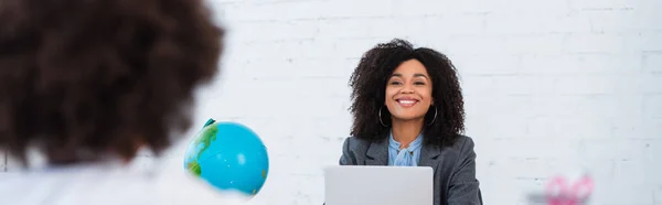 Sorridente Insegnante Afroamericana Che Guarda Bambino Sfocato Vicino Globo Laptop — Foto Stock