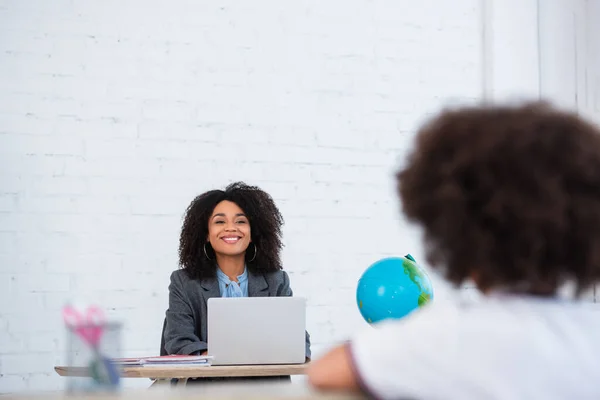 Fröhliche Afrikanisch Amerikanische Lehrerin Schaut Verschwommenes Mädchen Der Nähe Von — Stockfoto